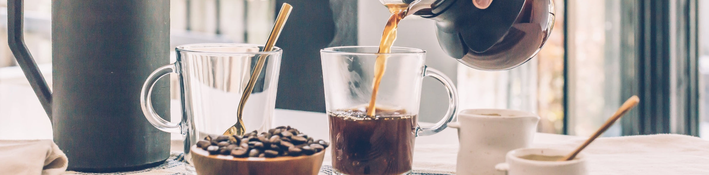 Frisch gebrühter Kaffee in Glasbechern auf einem Holztisch – Alps-Coffee bei Bella Vita – Mode & Lifestyle.