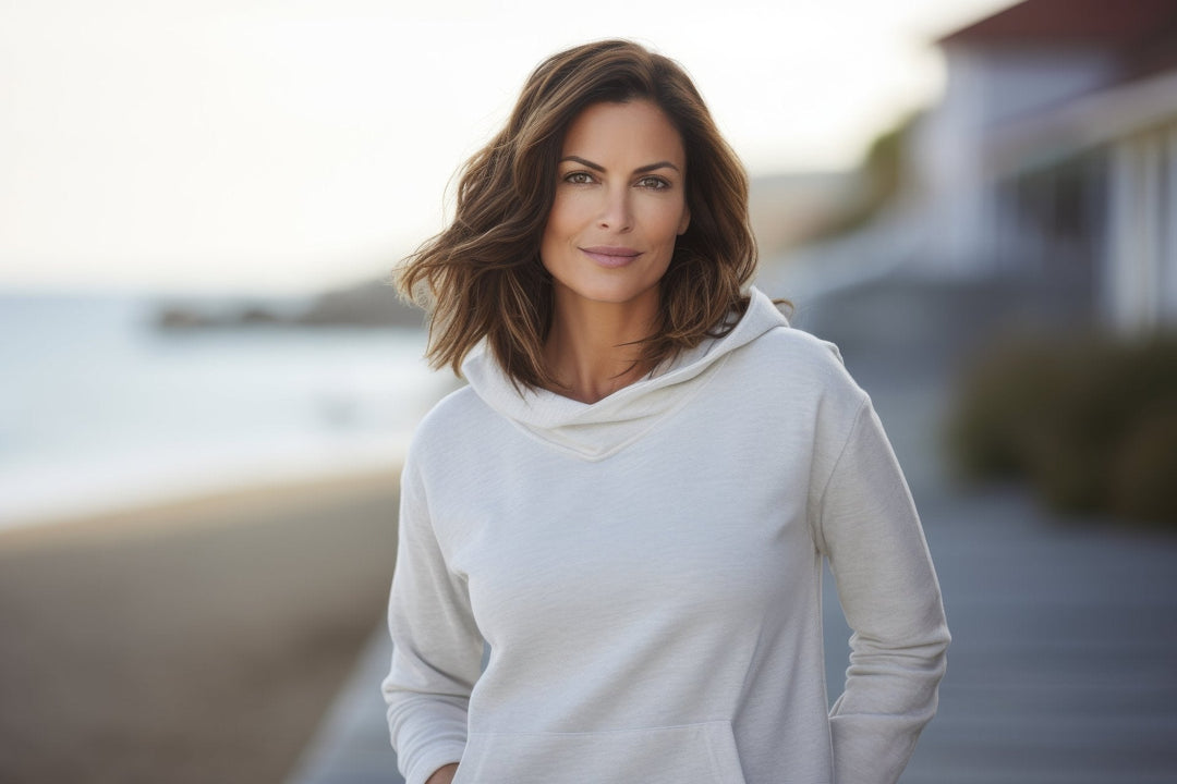 Frau im cremefarbenen Hoodie an der Promenade – lässiger und eleganter Look für kühle Tage, Sweatshirts, Pullover und Hoodies bei Bella Vita – Mode & Lifestyle.