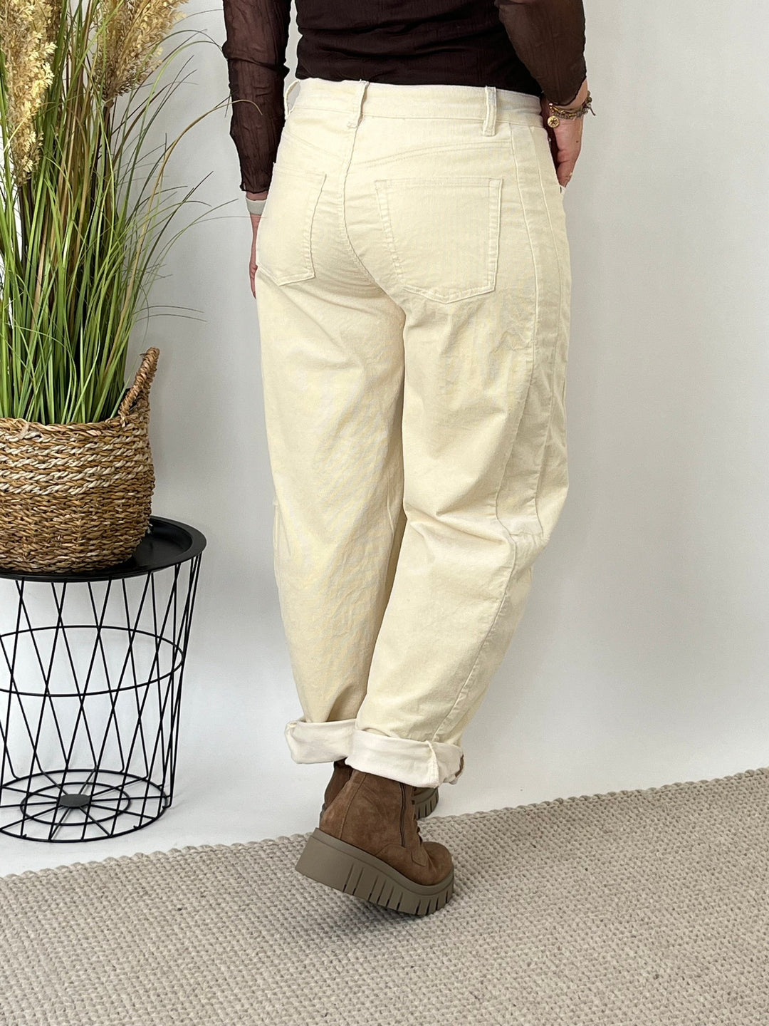 Rückansicht der beige Cordhose mit aufgerollten Beinen und dekorativen Seitennähten