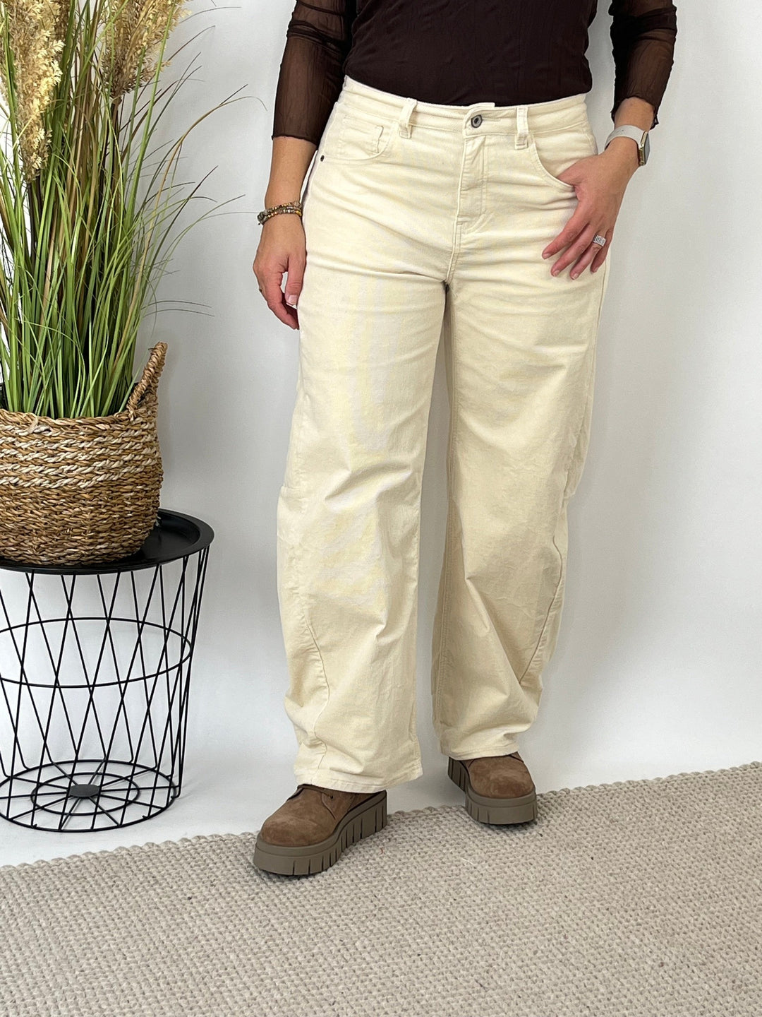 Nahaufnahme der Materialstruktur der beigen Cordhose mit geradem Schnitt und sichtbarer Stoffmaserung