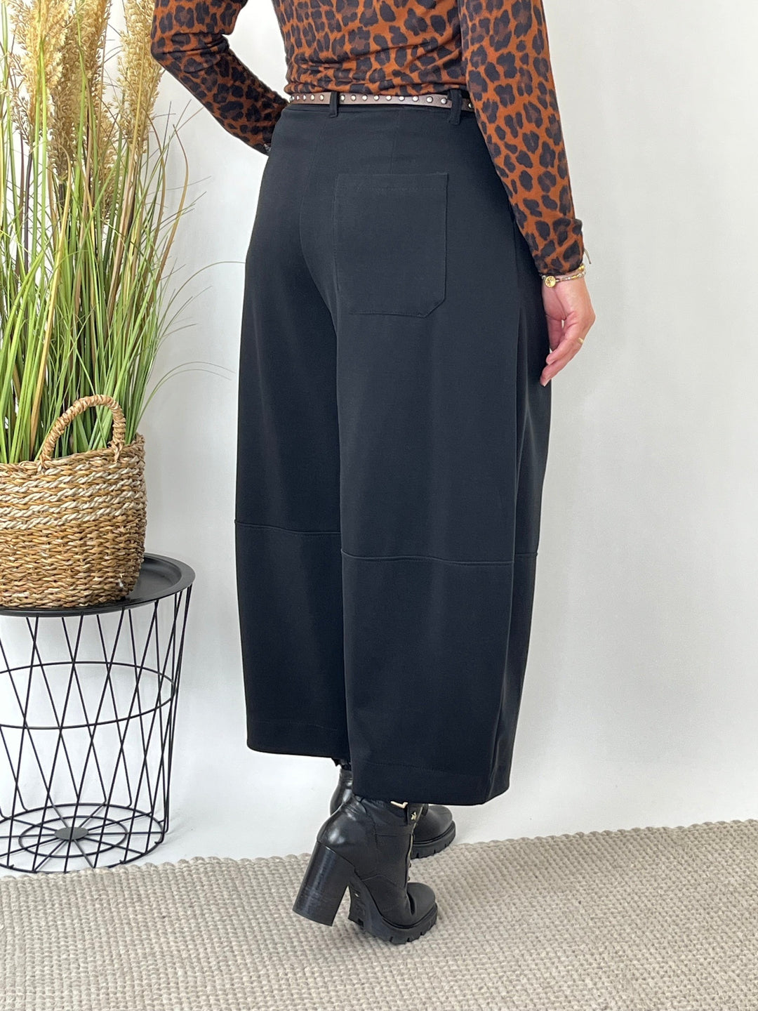 Rückansicht der schwarzen Barrelhose mit weiter Silhouette und gekürzter Länge