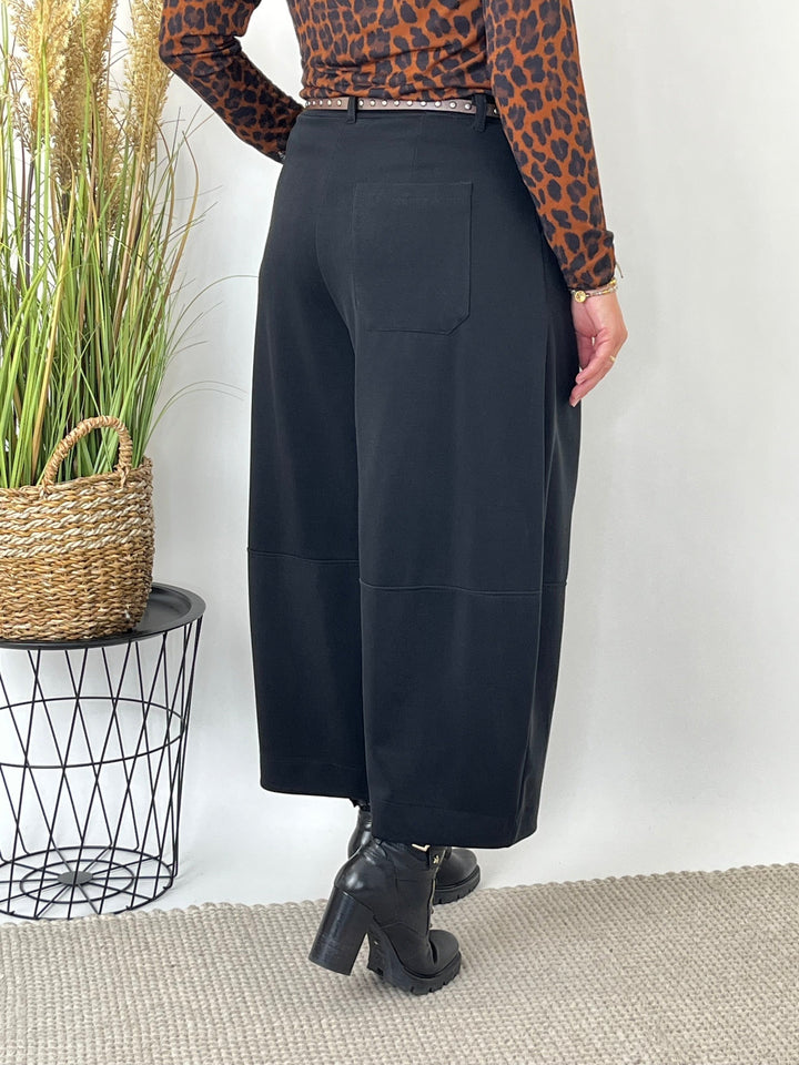 Rückansicht der schwarzen Barrelhose mit weiter Silhouette und gekürzter Länge