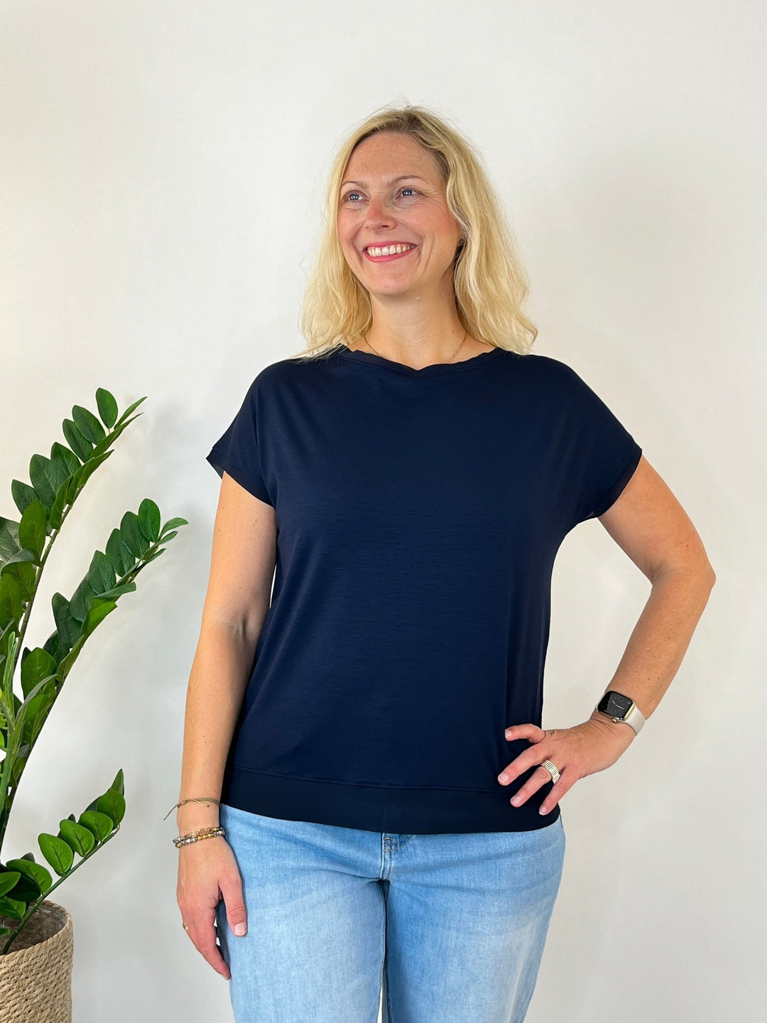 Dunkelblaues Shirt mit Chiffonkante, Frau mit Hand an Hüfte