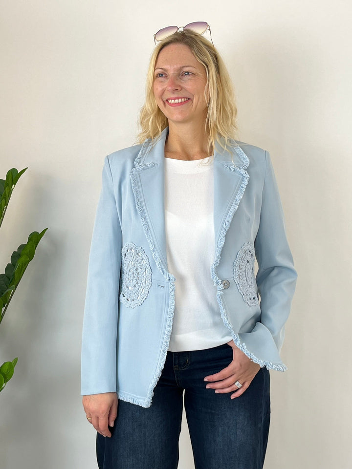 Hellblauer Blazer mit Häkelspitze und Fransenkante, getragen von Model