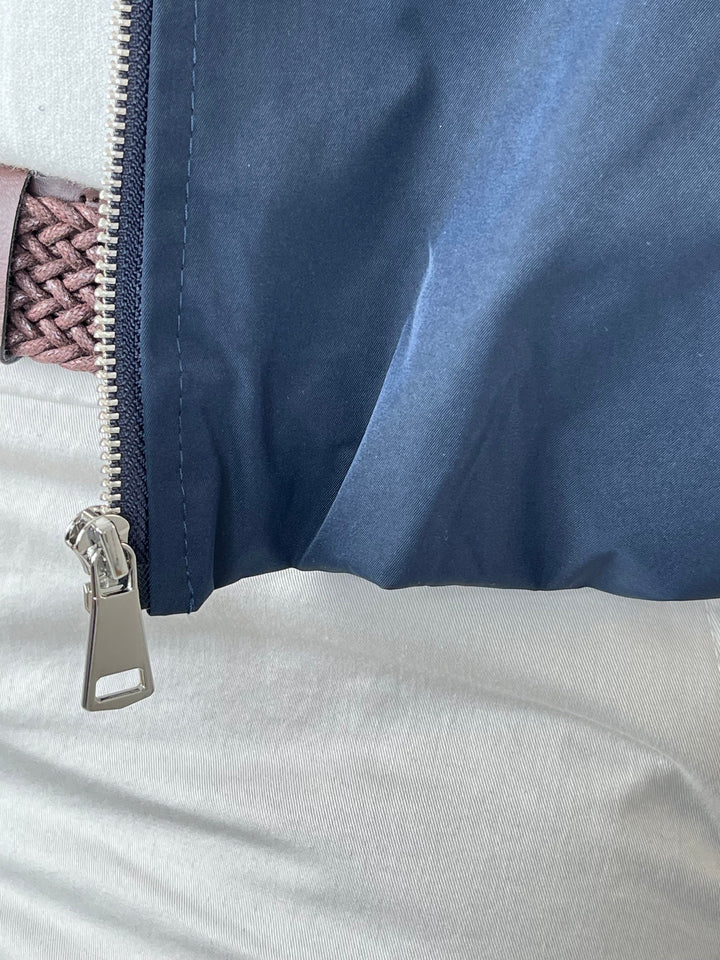 Silberner Reißverschlusszug an der marinen Blousonjacke