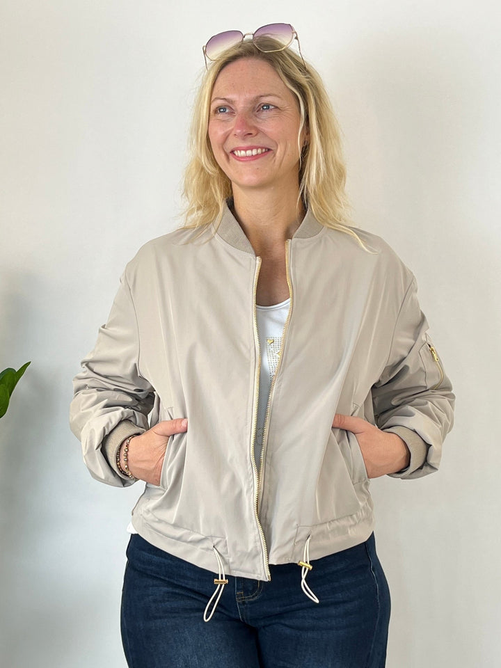 Frontalansicht beige Blouson mit zugezogenem Reißverschluss in Tasche