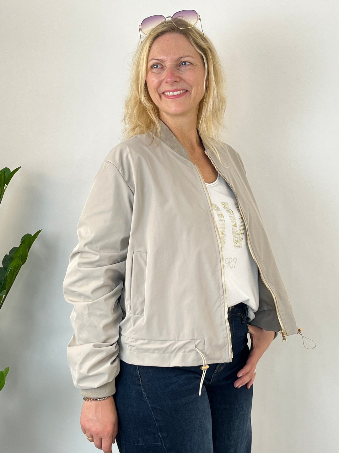Beige Blouson mit Tunnelzug und offenem Reißverschluss, getragen von Frau