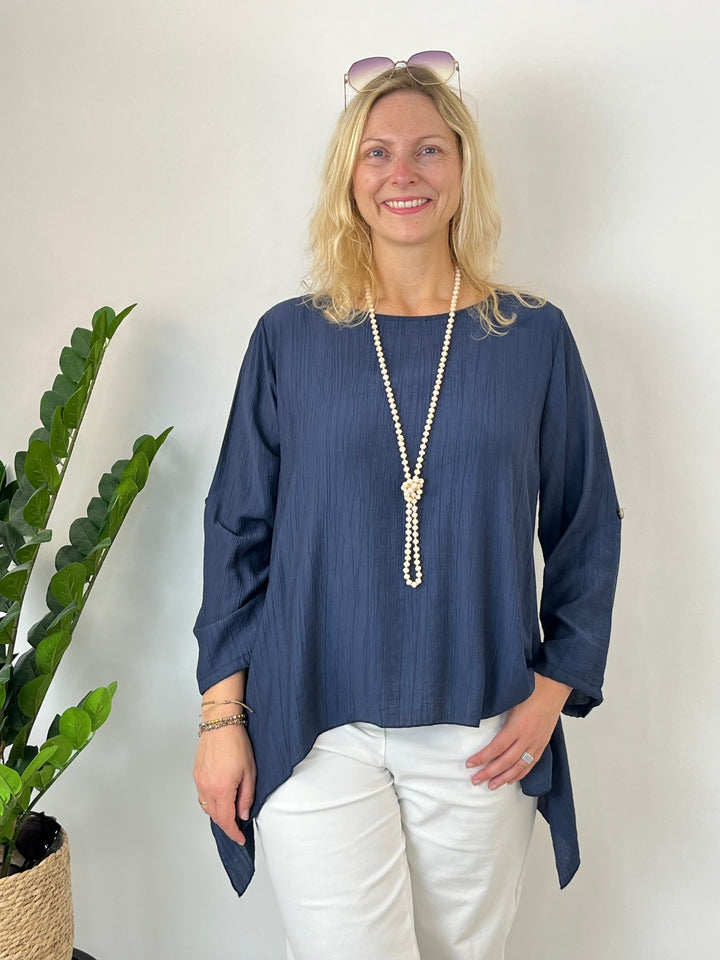 Marineblaue Tunika mit goldenem Ärmelknopf und schräg fallendem Saum