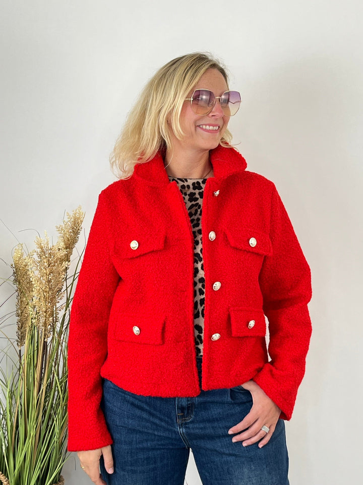 Rote Boucléjacke Milano mit Schmuckknöpfen und Pattentaschen, getragen über Jeans