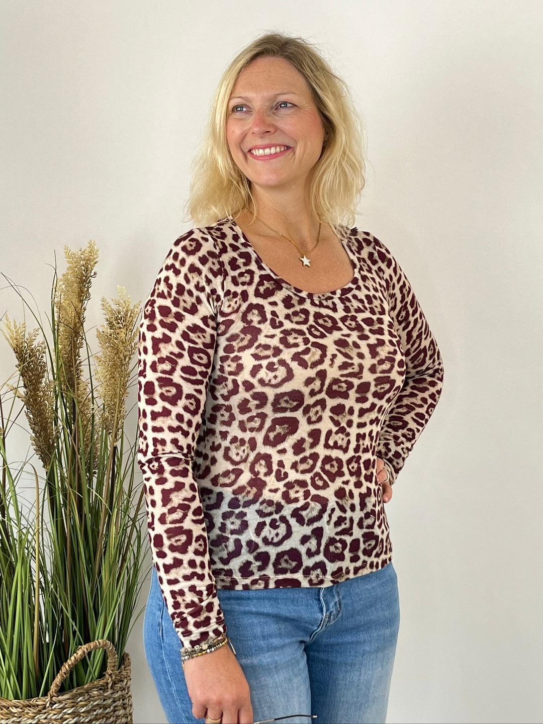 Bordeauxfarbene Frau im körpernahen Rundhals-Shirt mit Leopardenmuster