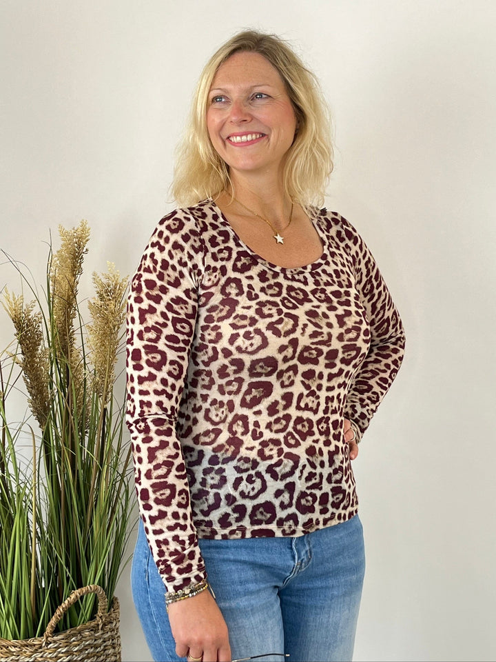 Bordeauxfarbene Frau im körpernahen Rundhals-Shirt mit Leopardenmuster