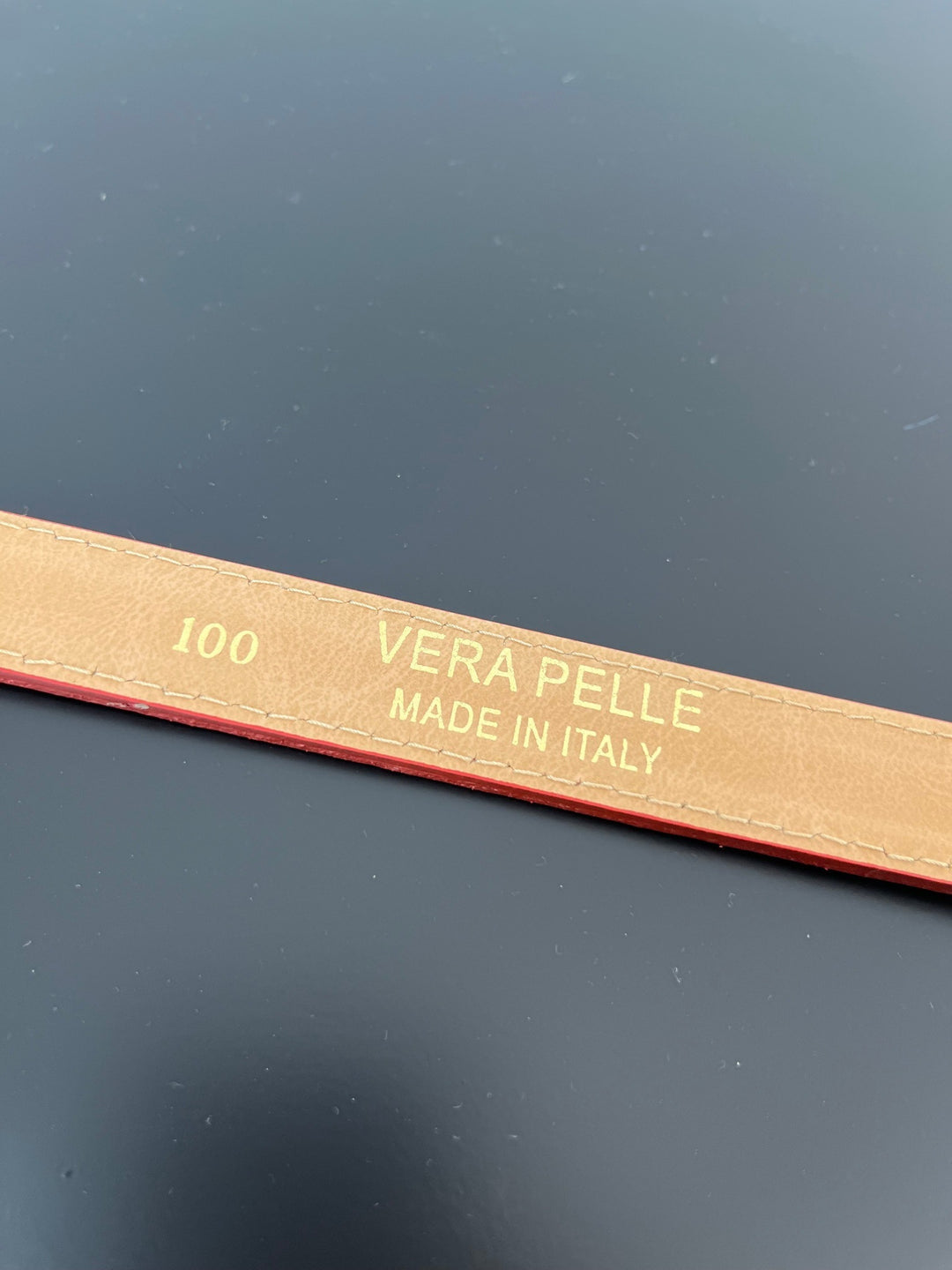 Detailaufnahme roter Echtledergürtel mit italienischer Prägung