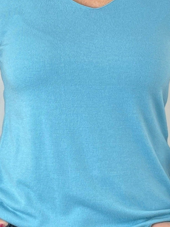 Türkisfarbener Pullover mit V-Ausschnitt im Seitenprofil