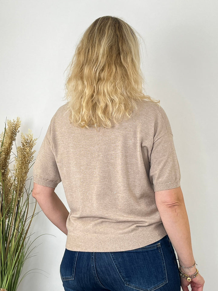 Rückansicht des beige Feinstrickpullovers mit Jeans