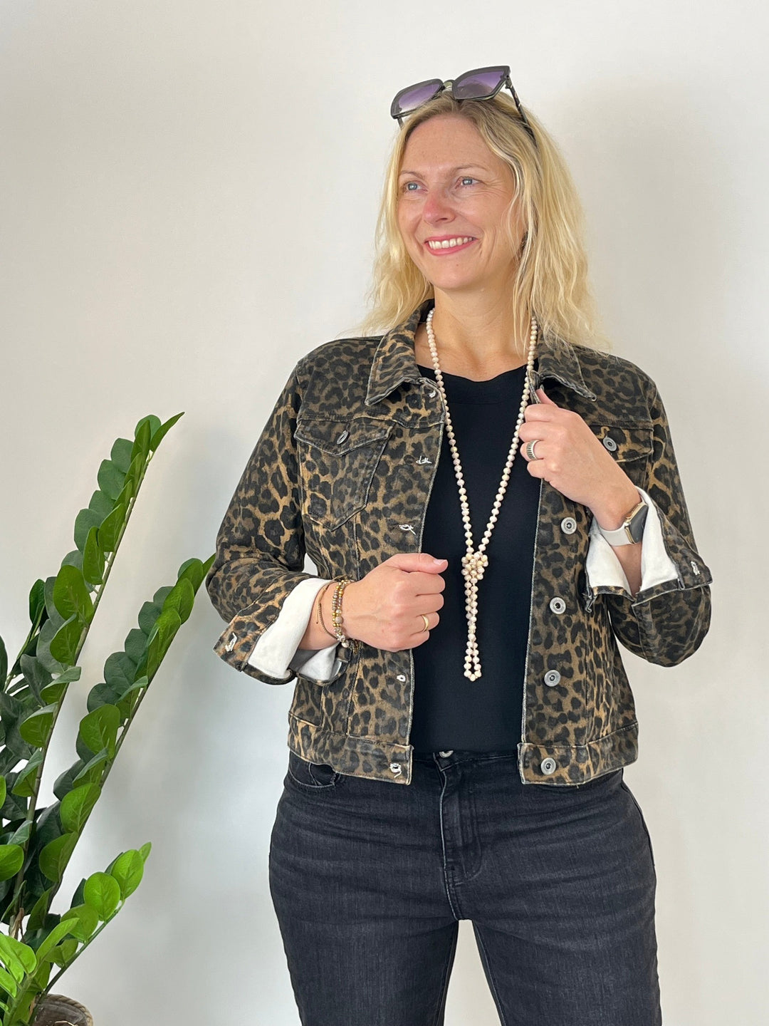 Frau in braun-schwarzer Leopard-Jeansjacke mit hochgekrempelten Ärmeln