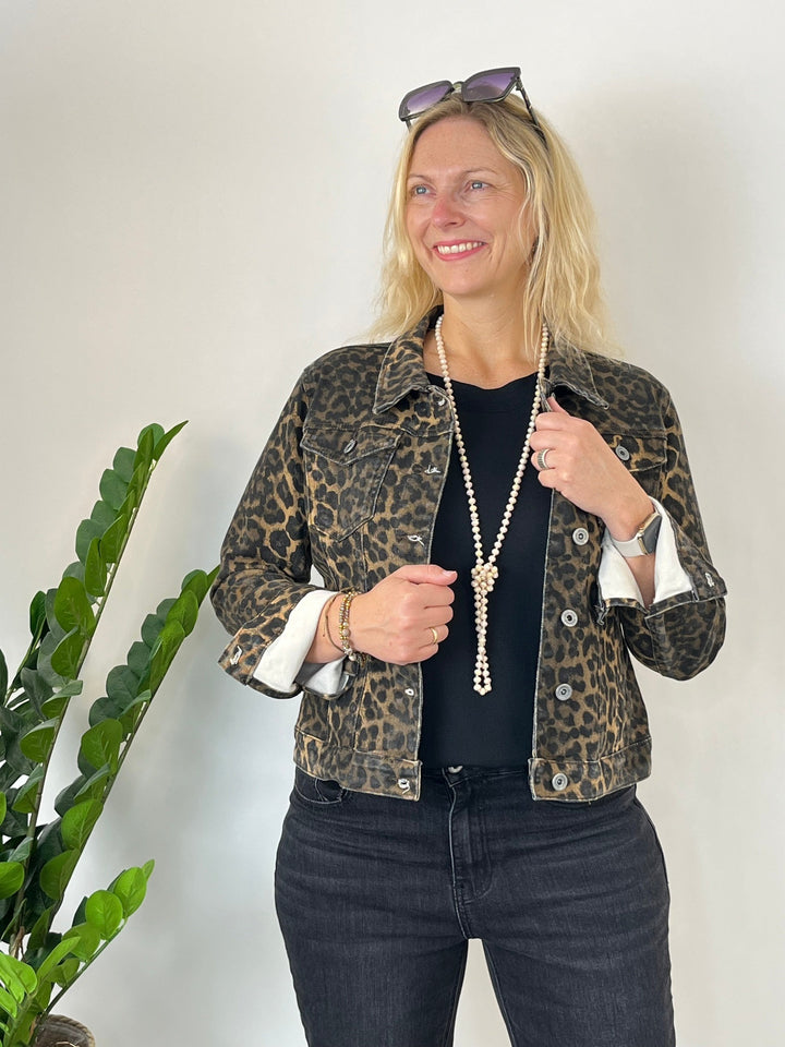 Frau in braun-schwarzer Leopard-Jeansjacke mit hochgekrempelten Ärmeln
