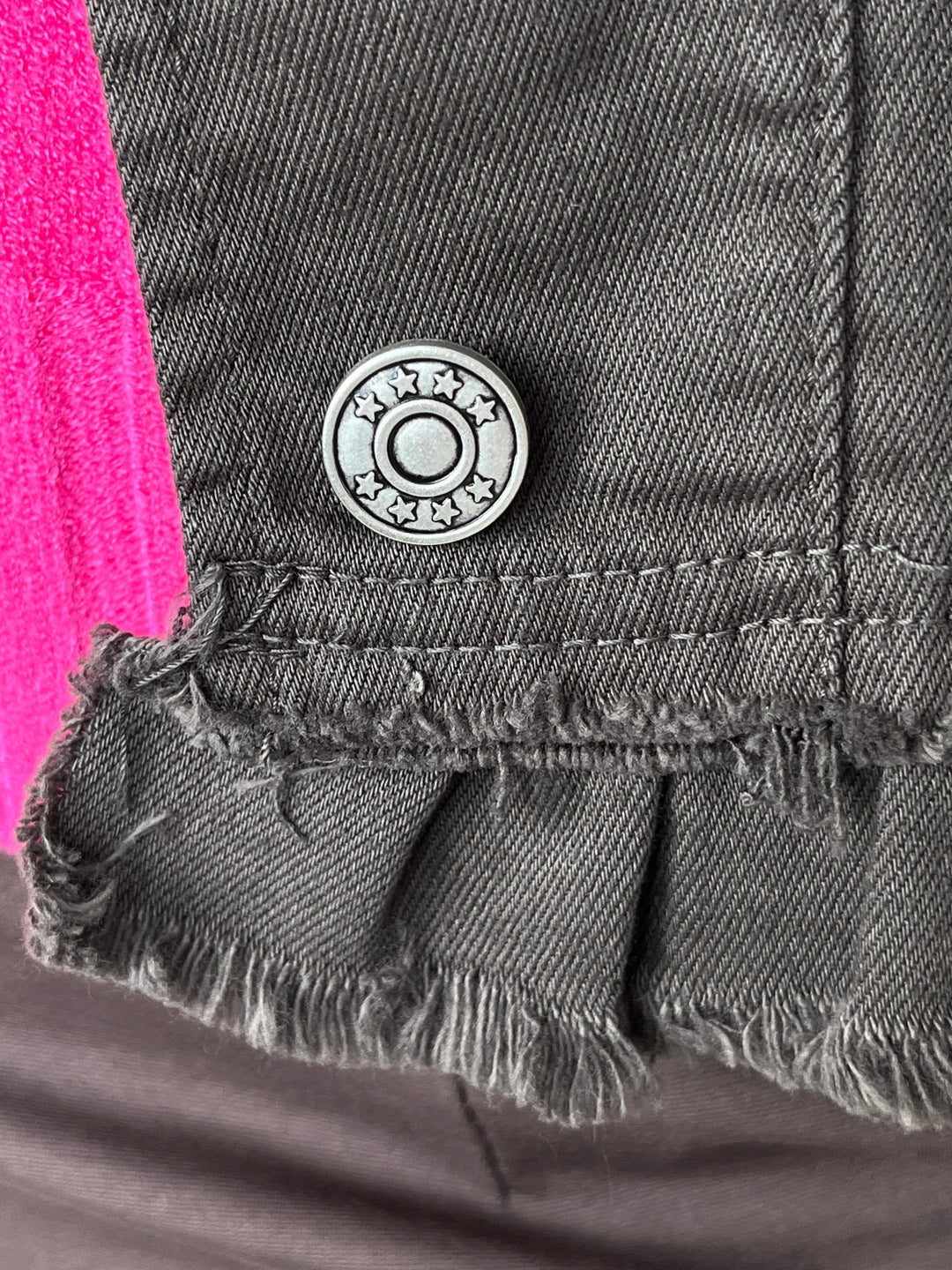 Silberner Stern-Knopf an der Saum-Rüsche der Jeansjacke