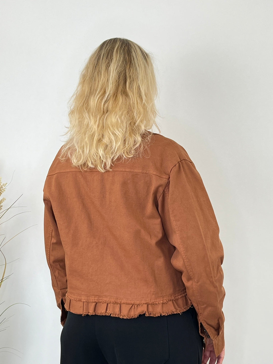 Rückansicht der rostroten Jeansjacke mit gerüschtem Saum