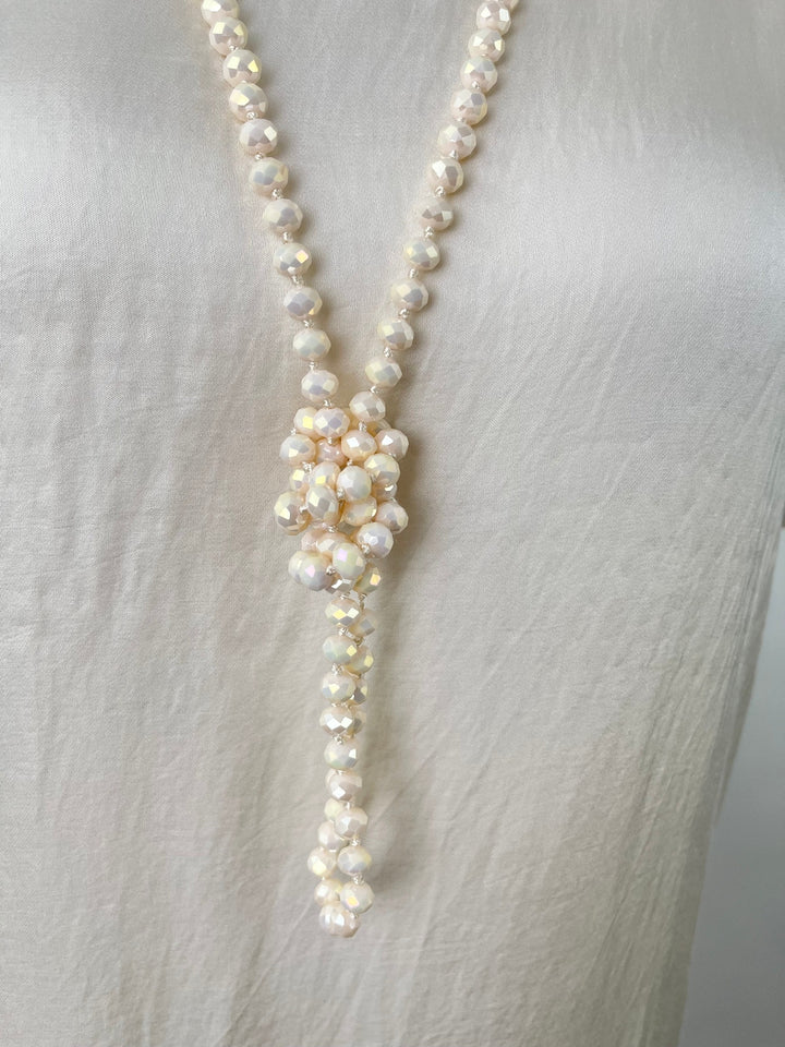 Nahaufnahme beige Kette mit facettierten Glassteinen und zentralem Knotendetail