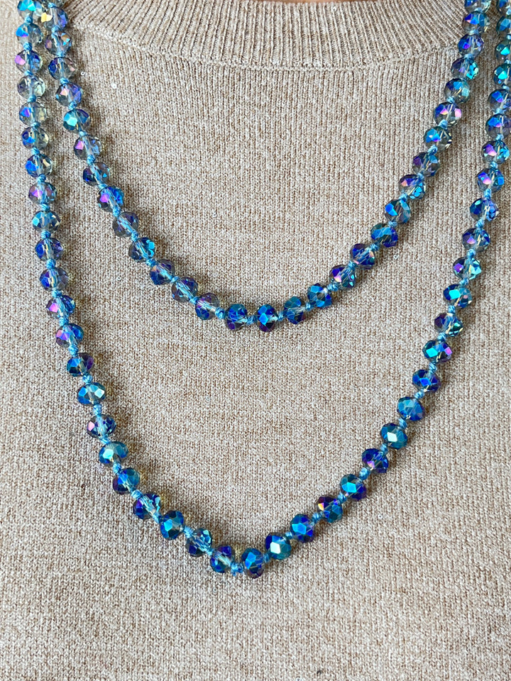Offen getragene blaue Glasperlenkette mit irisierendem Glanz