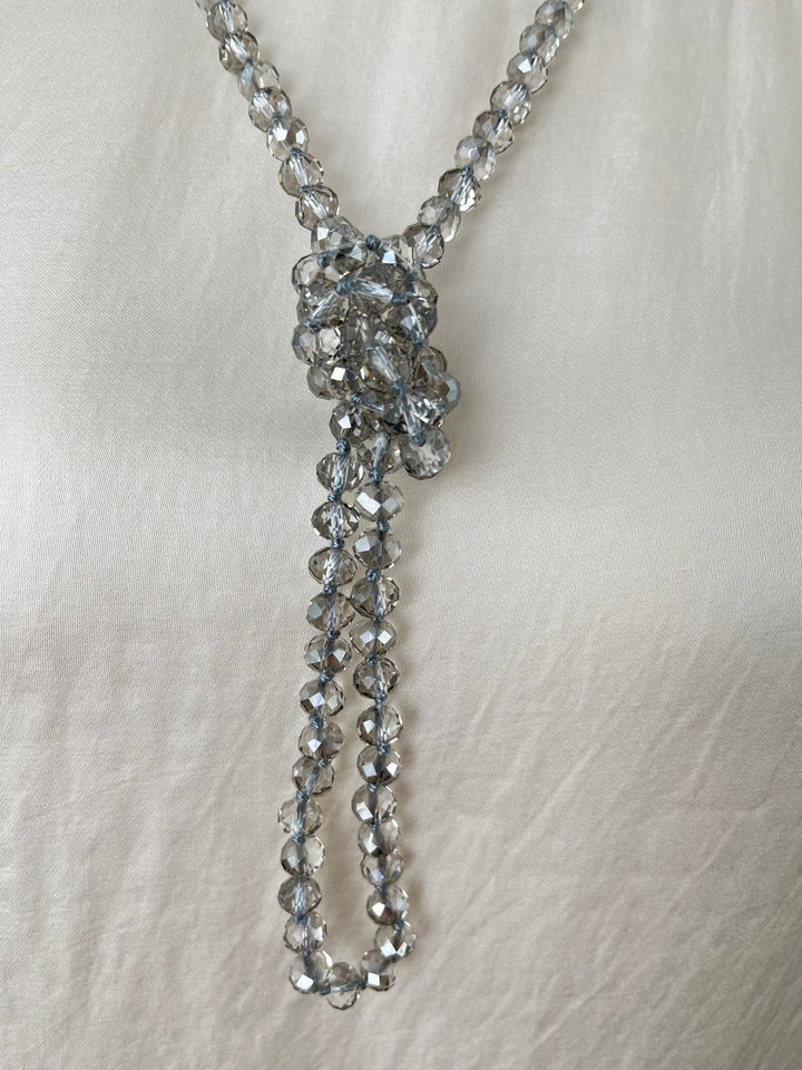 Nahaufnahme gebundener grauer Glaskette als Y-Kette mit hellblauer Schnur