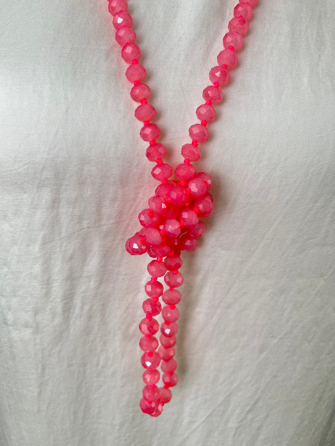 Detailansicht knotigen Tassel-Abschlusses aus rosa Glassteinen