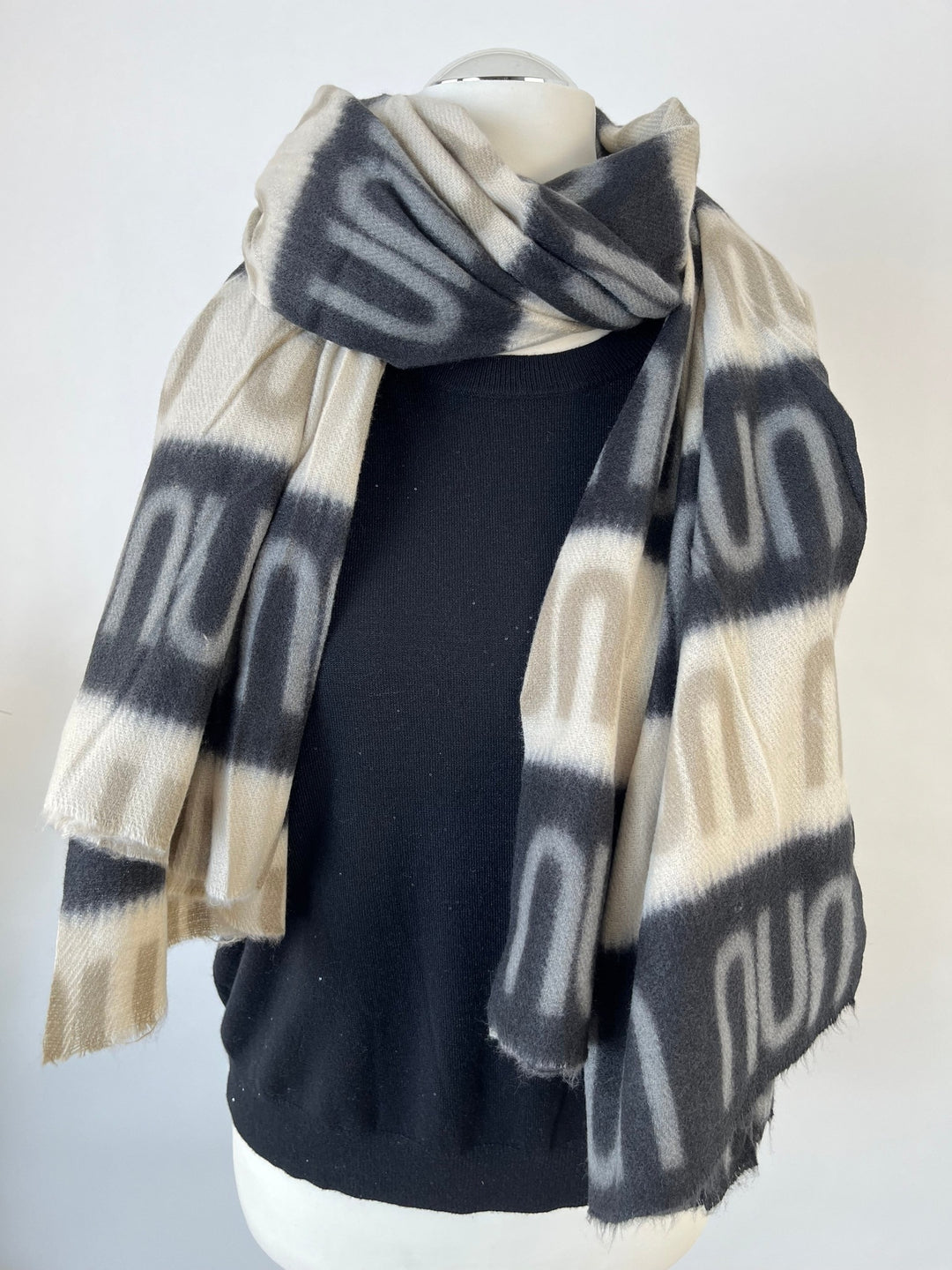 Grafischer Kuschelschal am Hals eines Mannequins, vielseitig tragbar
