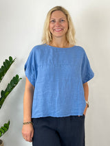 Hellblaues Leinen-Blusenshirt mit V-Ausschnitt und sichtbarer Stoffstruktur frontal