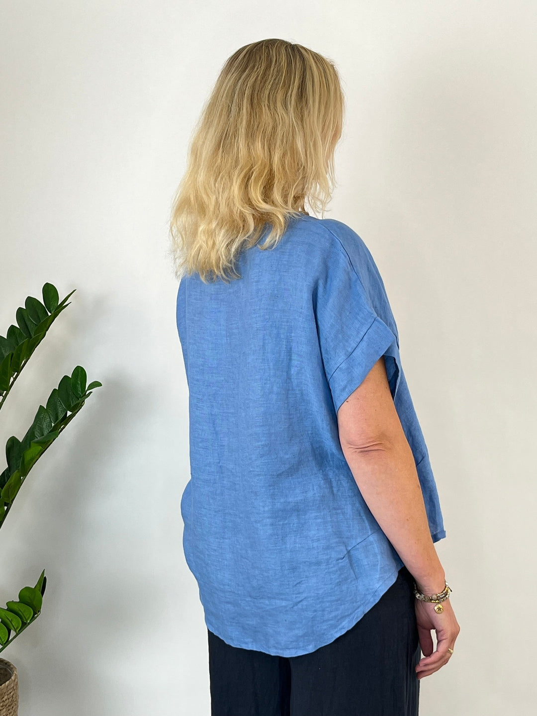 Rückansicht des hellblauen Leinen-Blusenshirts mit weich fallendem Saum