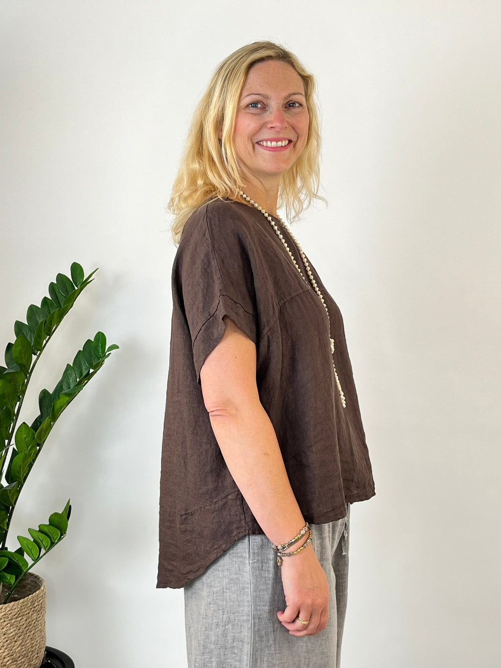 Braunes Leinen-Blusenshirt mit Boxy-Schnitt und asymmetrischem Saum an Frau