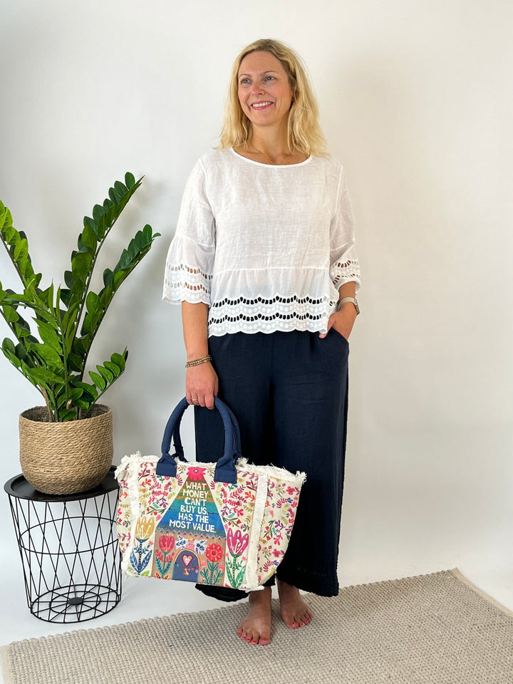 Weiße Leinenbluse mit Rüschenabschluss und durchbrochener Stickerei im Look