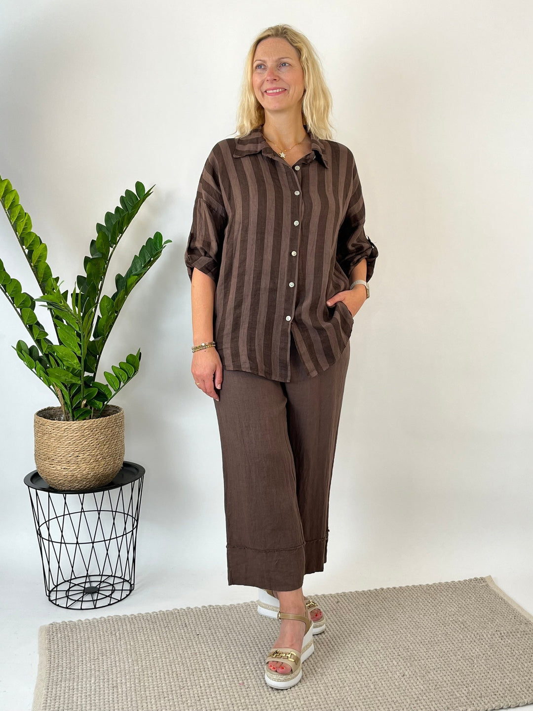 Braune gestreifte Leinenbluse mit Knopfleiste im Studio getragen