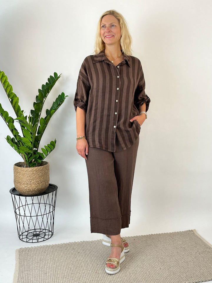 Braune gestreifte Leinenbluse mit Knopfleiste im Studio getragen