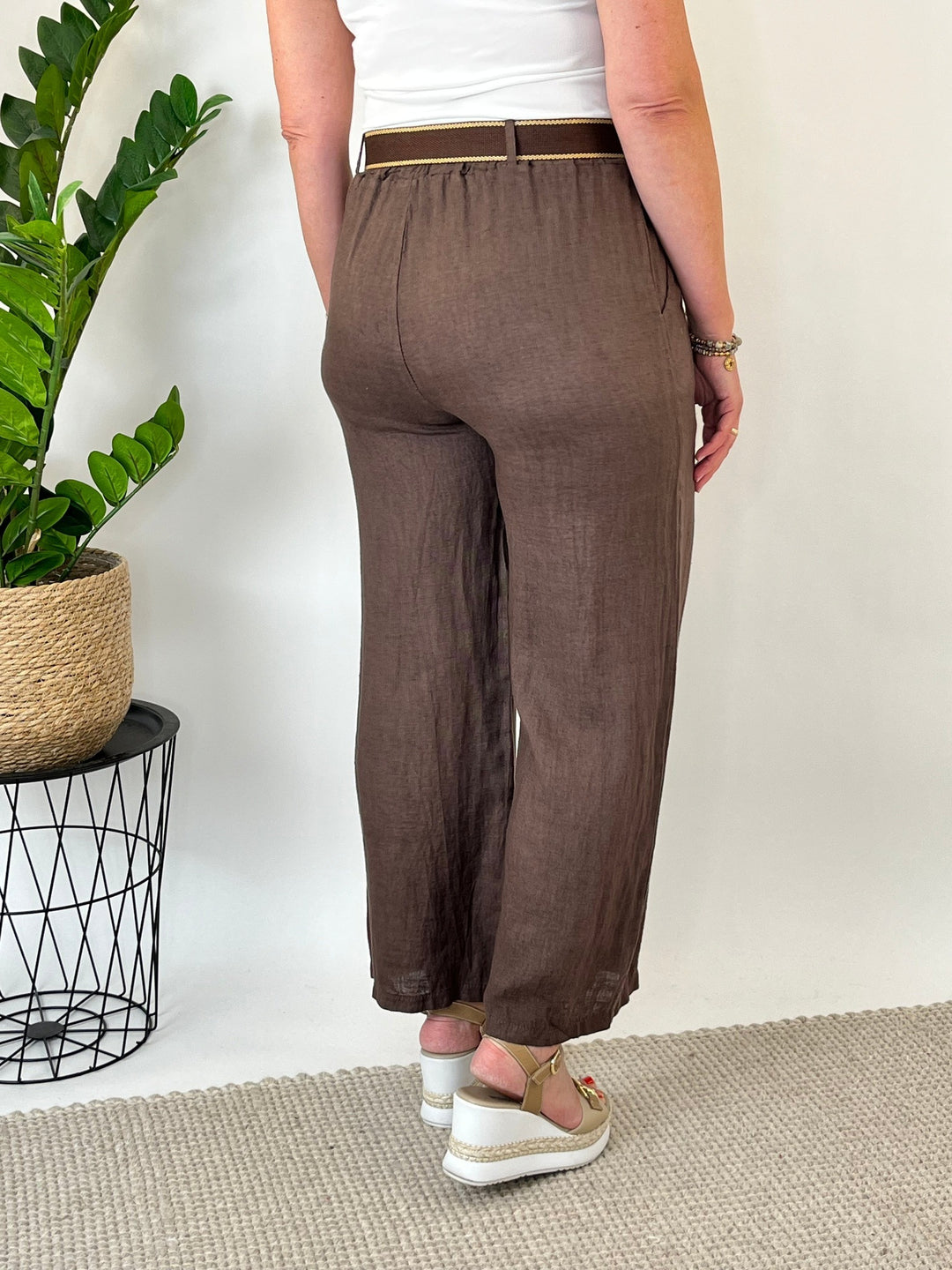Rückansicht braune Leinenhose mit elastischem Bund und Ziergürtel