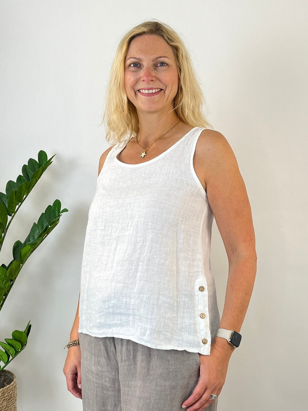 Frauen weißes Leinentop mit Holzknöpfen im lässigen Sommer-Look kombiniert