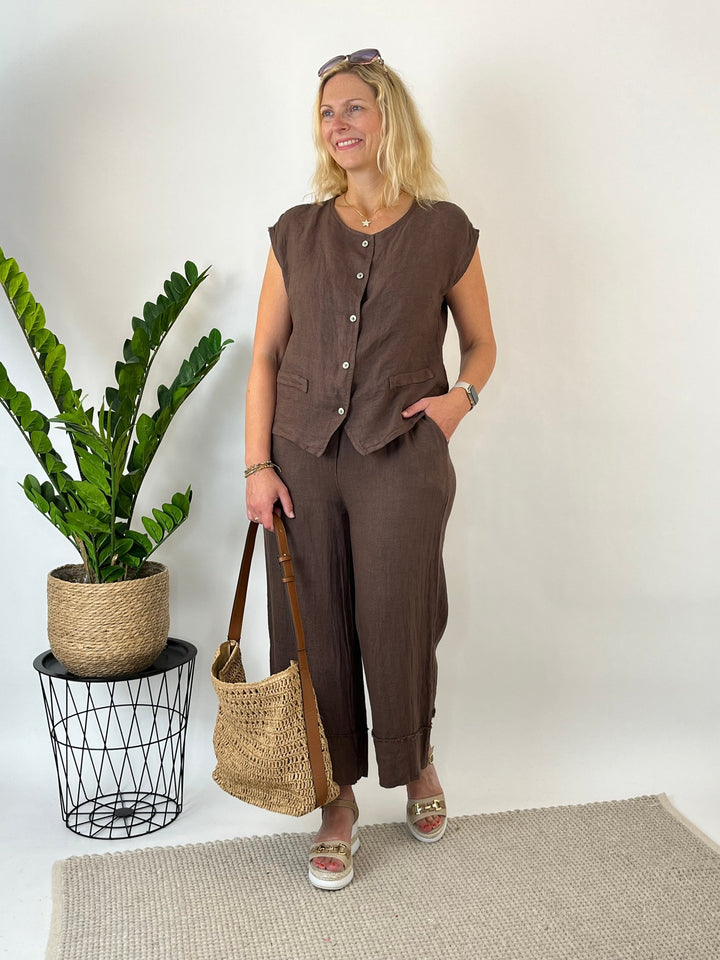 Damen braune Leinenweste mit Strohtasche und Plateausandalen Sommeroutfit