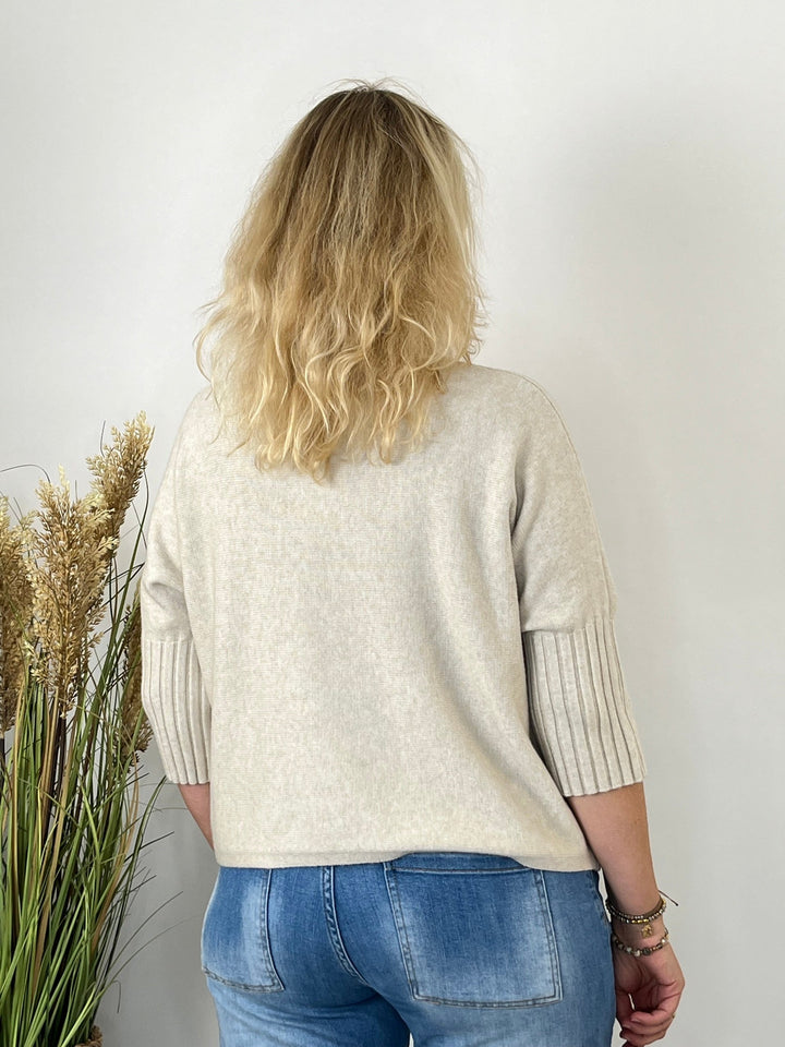 Rückansicht beiger Strickpullover mit Stehkragen und breiten Rippbündchen