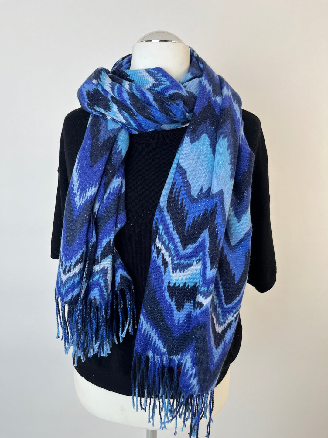 Blauer Zickzack-Schal mit Fransen um das Hals eines Mannequins