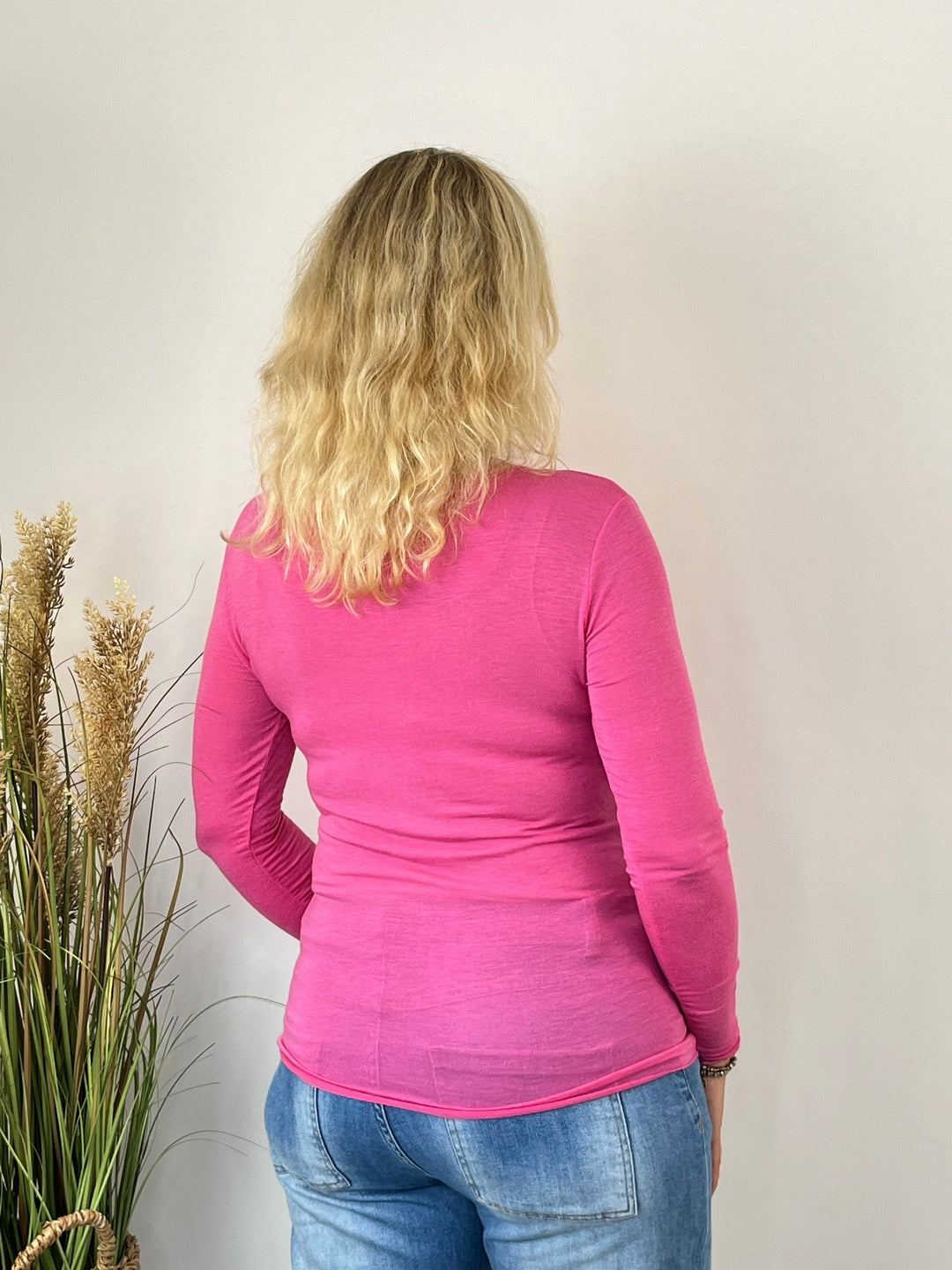 Rückansicht des figurbetonten pinken Langarmshirts