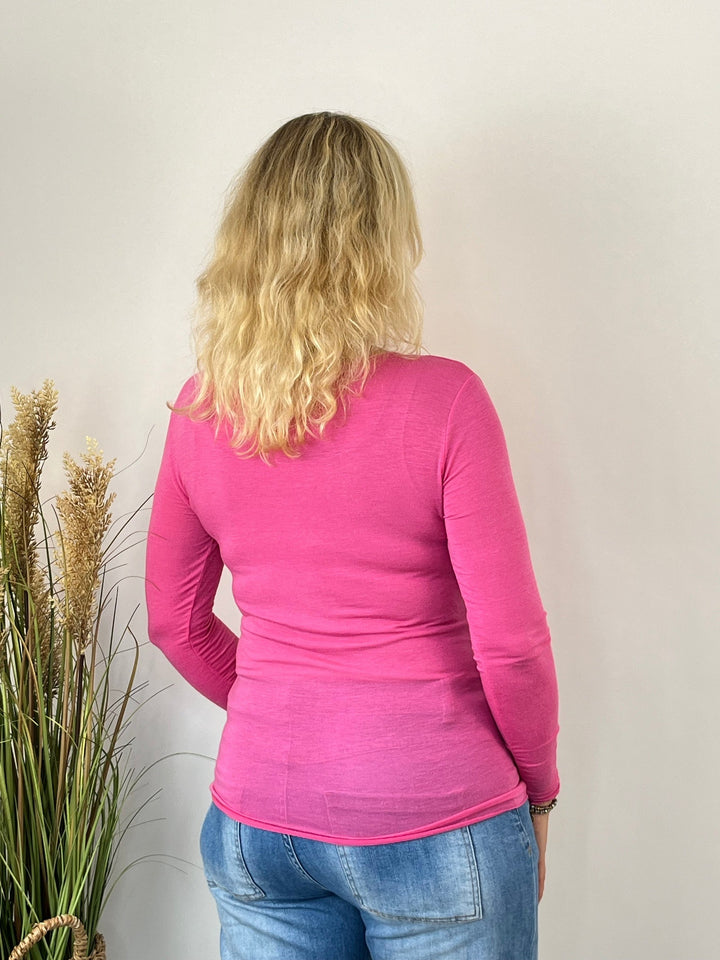 Rückansicht des figurbetonten pinken Langarmshirts