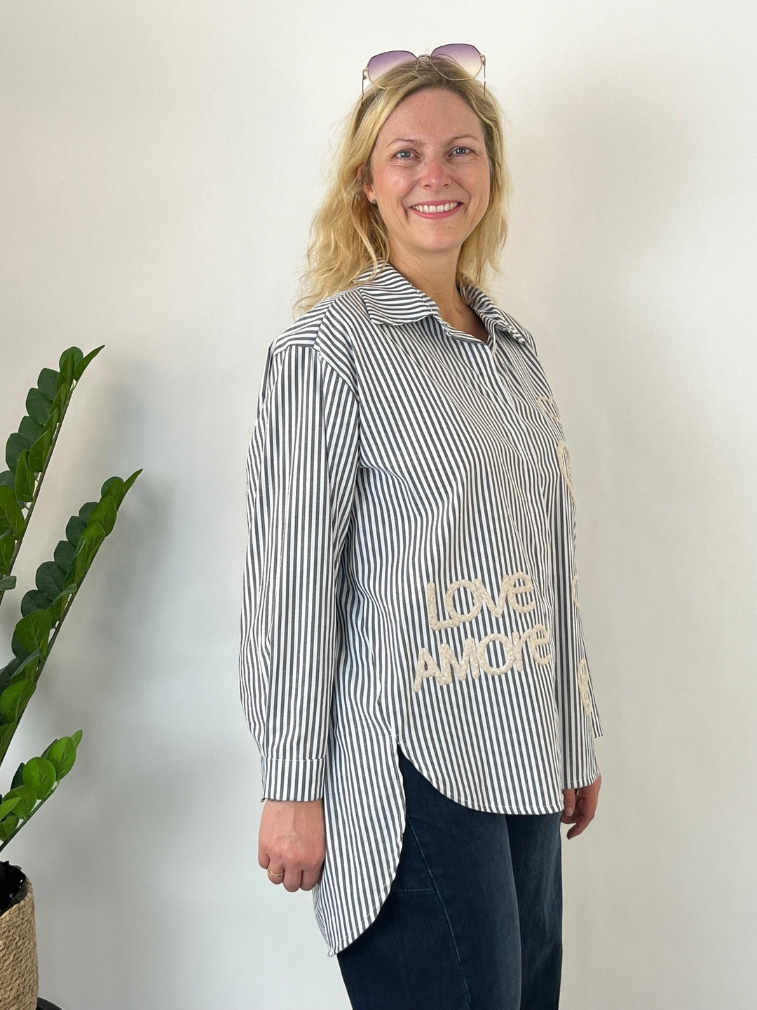 Seitenansicht grauer Longbluse mit seitlichem Schlitz und Love AMORE Applikation