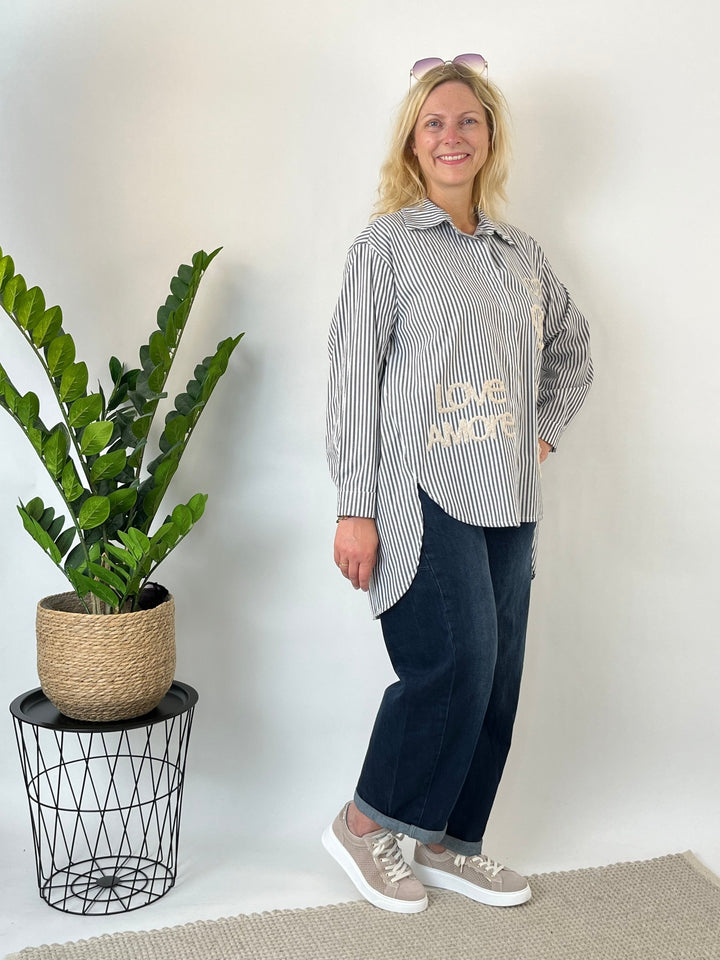 Gesamtansicht grau-weiße Hemdbluse mit Stickerei, Knopfleiste und Seitenschlitzen