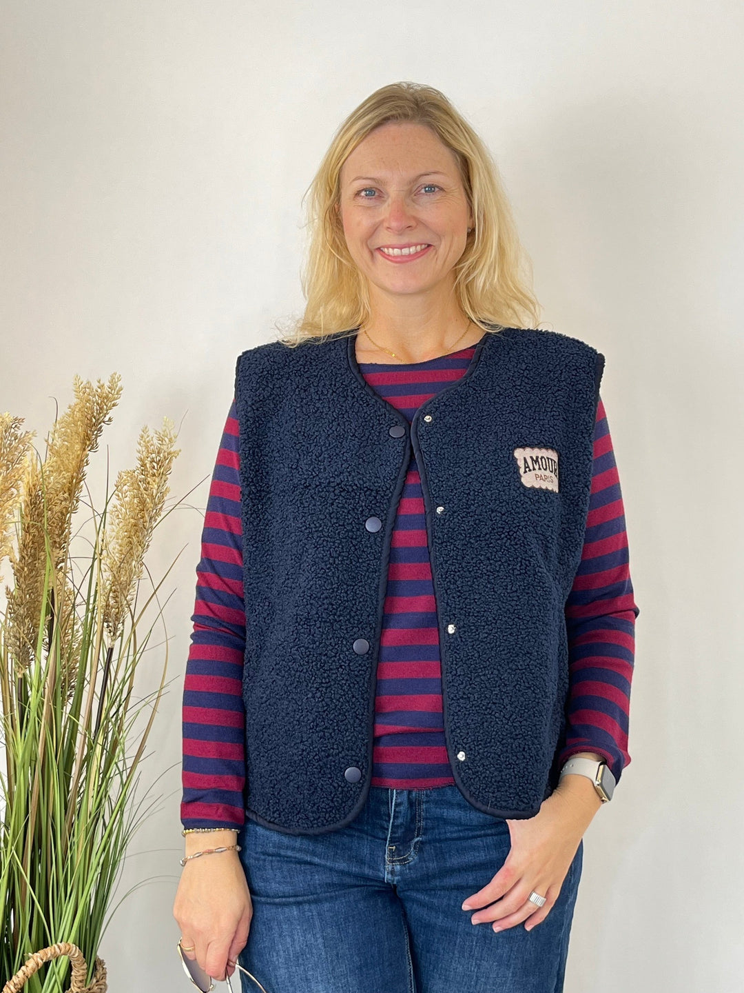 Gestrickter Streifenpullover kombiniert mit dunkelblauer Fleece-Weste