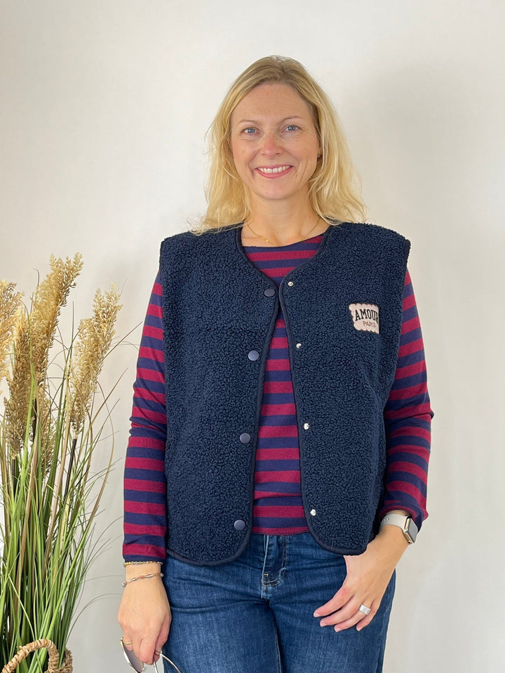 Gestrickter Streifenpullover kombiniert mit dunkelblauer Fleece-Weste