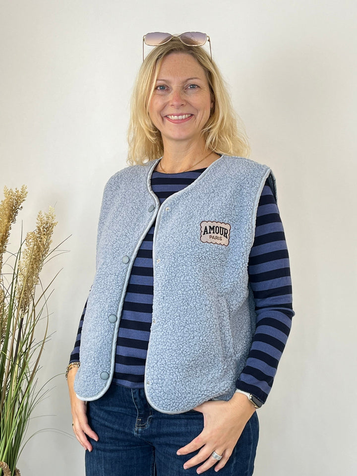 Gestrickter Pullover unter heller Fleece-Weste für layering Look
