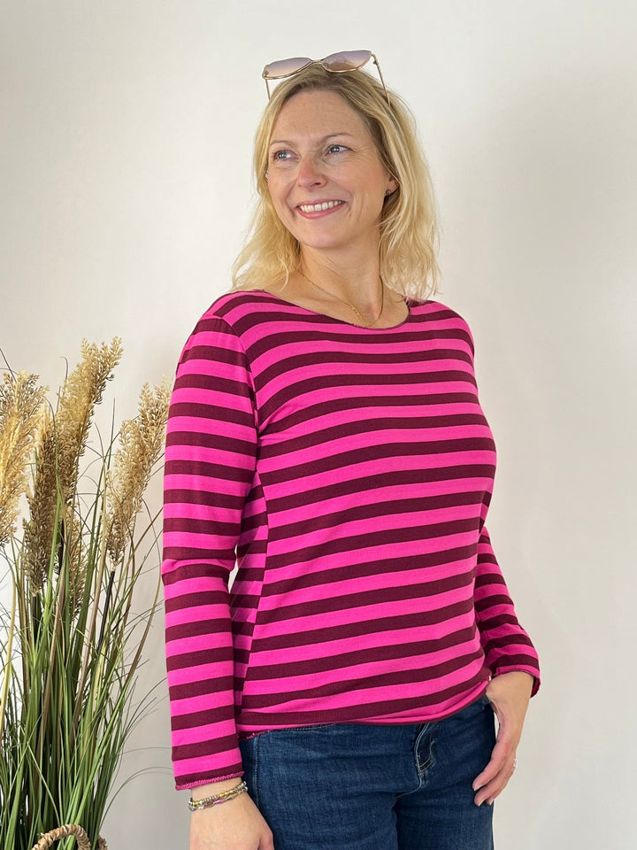 Pink-rot gestreifter Strickpullover mit Rundhals, getragen von einer Frau