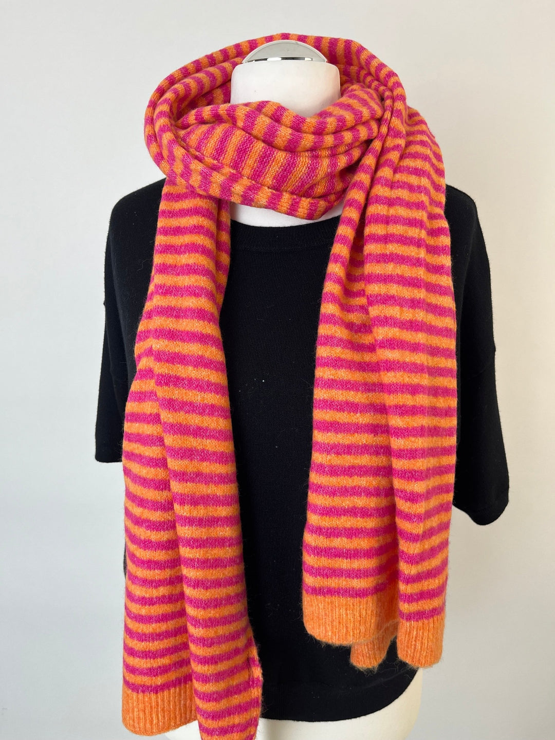 Strickschal Happy Stripes um Hals drapiert, gerippte Enden sichtbar