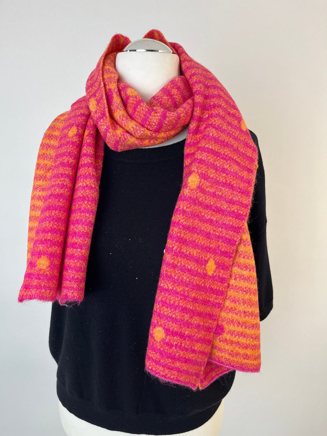 Drapiertes pink-oranges Strickmuster-Schal am Hals eines Mannequins
