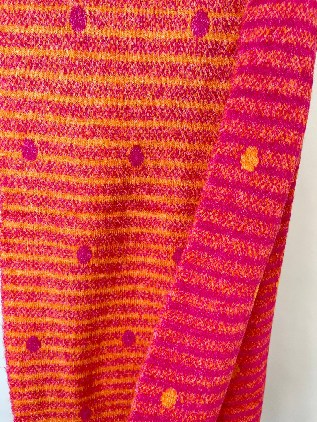 Nahaufnahme der Viskose-Wollmischung des pink-orangen Schals mit Streifenmuster
