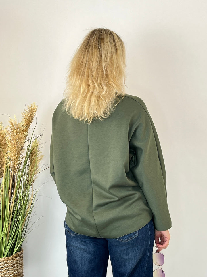 Rückansicht des Sweaters mit verlängerter Passform